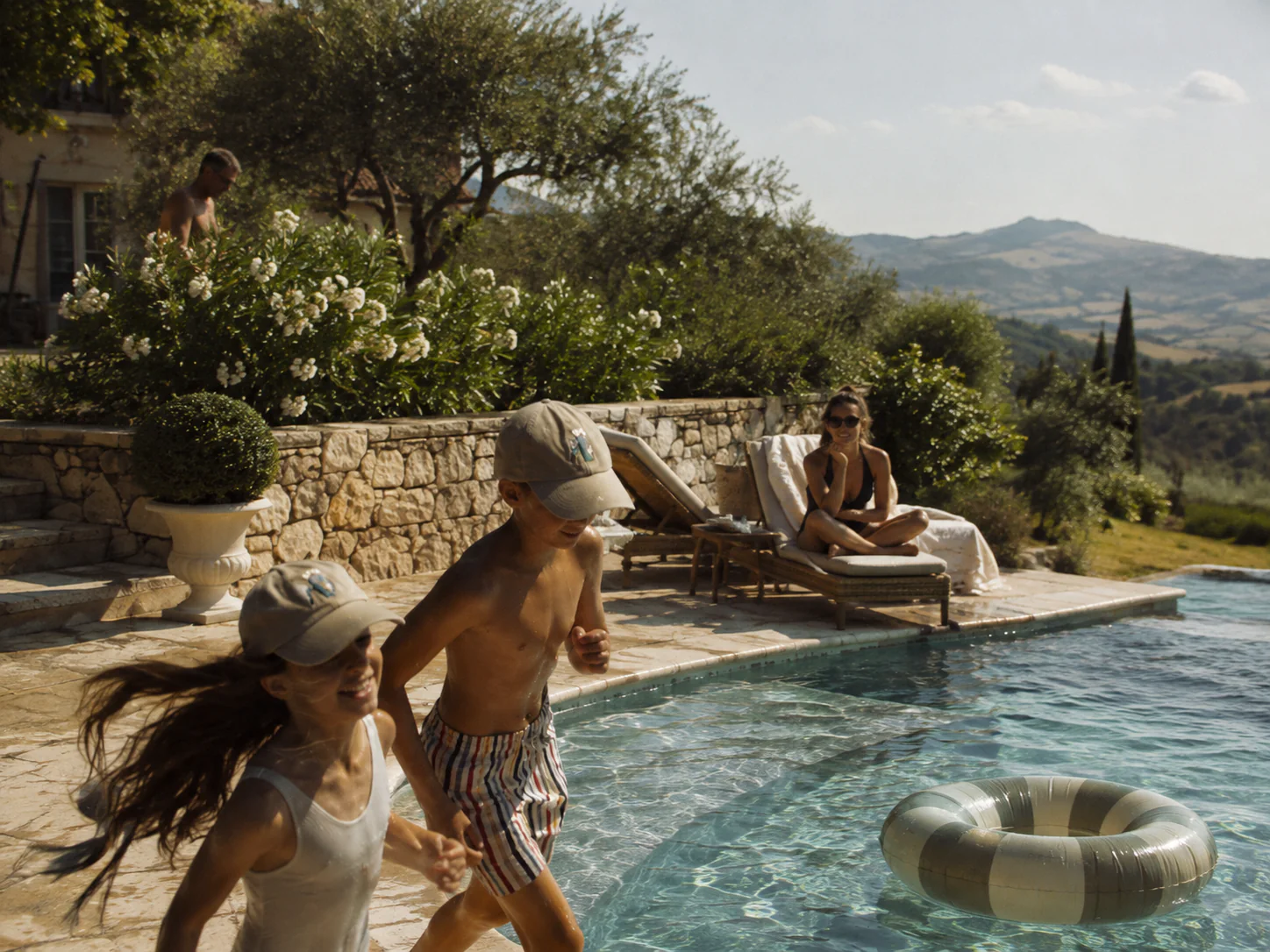 Family enjoying a Mediterranean villa pool with mountain views